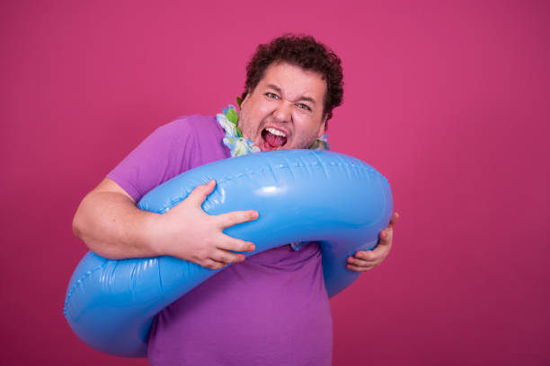 istock Vacation and holidays. Funny fat man with an inflatable ring. 1426505912