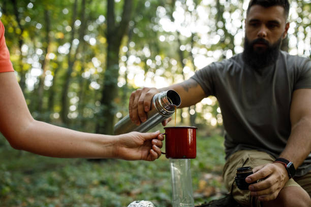 istock Woman holding a cup while her friend pours her coffee from thermos 1426512685