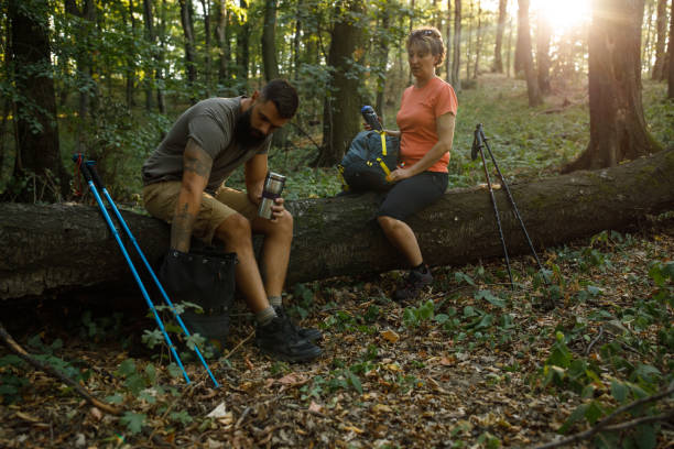 istock Hikers sitting on the fallen tree in the forest while taking a break from walking 1426512705