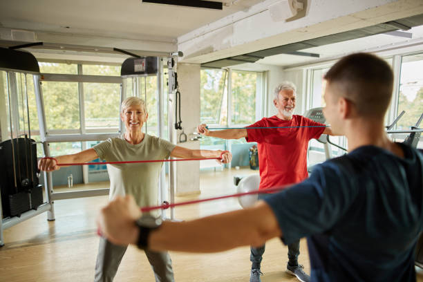 istock Senior couple exercising with personal trainer using resistance band 1426513901