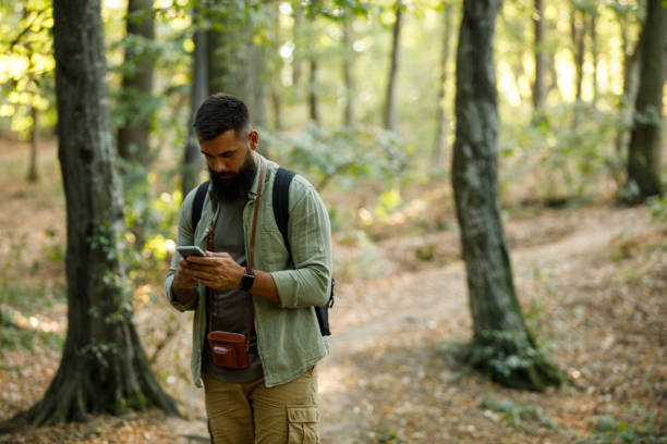 istock Man feeling lost during a forest hike, checking GPS coordinates via smart phone 1426514260