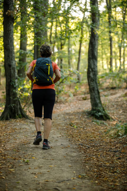 istock Rear view of female backpacker going on a relaxing forest hike 1426515567