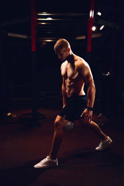 hombre atlético haciendo ejercicios con kettle bell en el gimnasio - kettle bell activity aerobics athlete fotografías e imágenes de stock