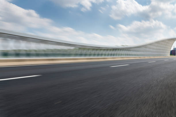 Motion blurred asphalt road on the bridge in downtown with cloudy sky. stock photo