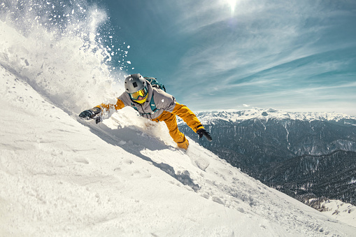 Young woman snowboarding in mountains