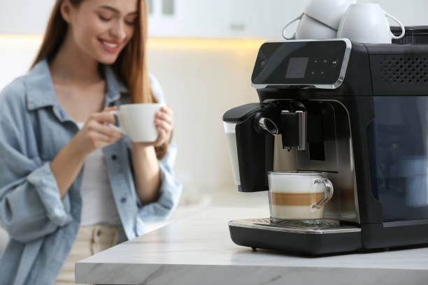 istock Young woman enjoying fresh aromatic coffee in kitchen, focus on modern machine 1426543301