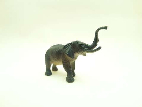 Children's toys made of solid plastic with the animal character of an elephant lifting its trunk on a white background