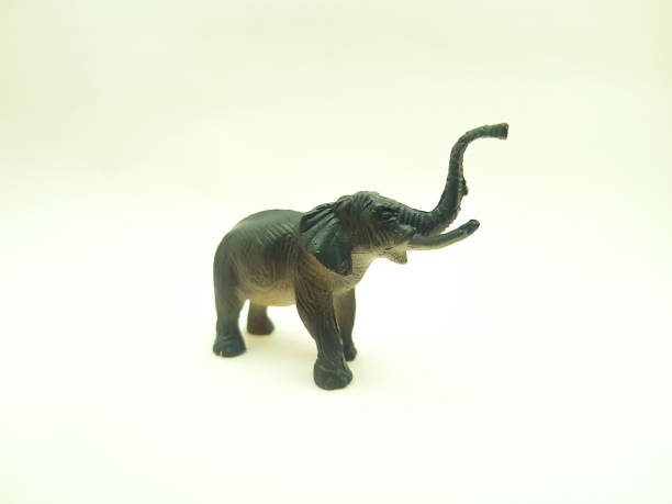 Children's toys made of solid plastic with the animal character of an elephant lifting its trunk Children's toys made of solid plastic with the animal character of an elephant lifting its trunk on a white background elephant figurine stock pictures, royalty-free photos & images