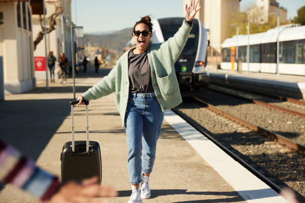 kobieta przyjeżdża pociągiem i macha radośnie do przyjaciela. - people traveling travel leaving disembarking zdjęcia i obrazy z banku zdjęć