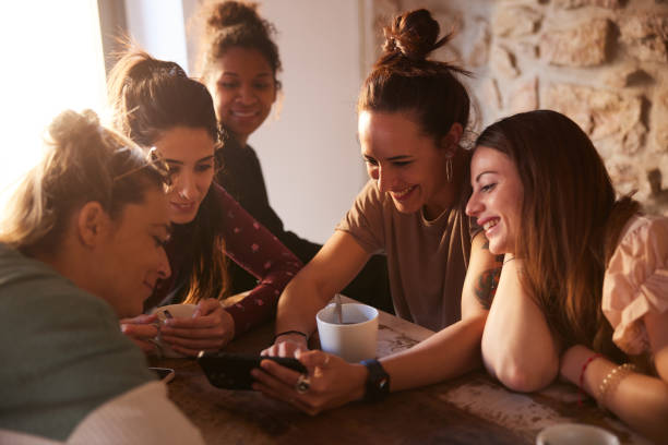 Group of friends in a rental apartment looking at a smartphone. stock photo