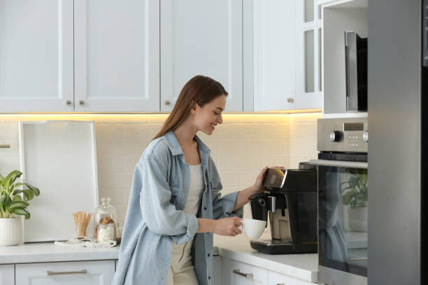 istock Young woman preparing fresh aromatic coffee with modern machine in kitchen 1426544311