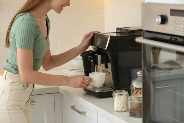 istock Young woman preparing fresh aromatic coffee with modern machine in kitchen, closeup 1426544478