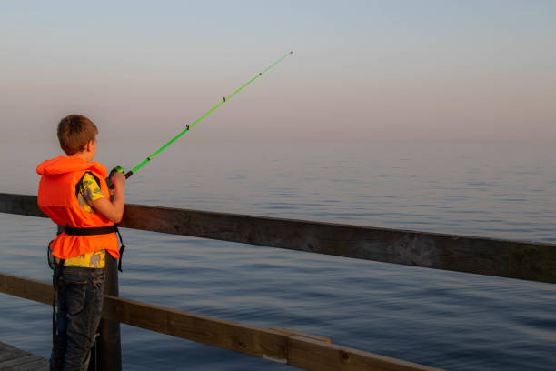 chłopiec łowiący ryby w oceanie z molo - sweden fishing child little boys zdjęcia i obrazy z banku zdjęć