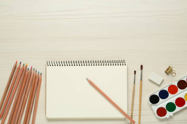 istock Flat lay composition with blank sketchbook on white wooden table. Space for text 1426546381