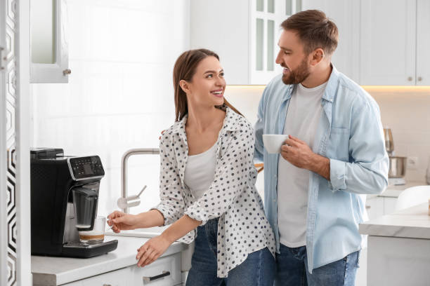istock Happy couple preparing fresh aromatic coffee with modern machine in kitchen 1426546944