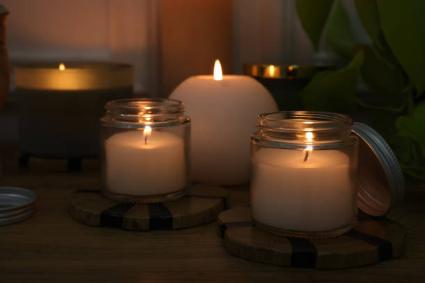 istock Burning candles on wooden table indoors, closeup 1426547673