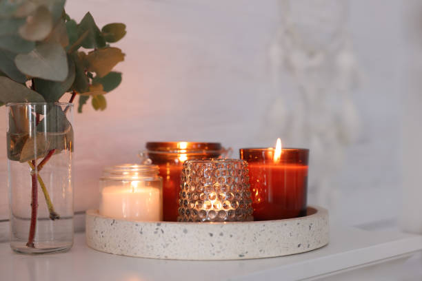istock Burning candles on mantel near white wall indoors 1426547678