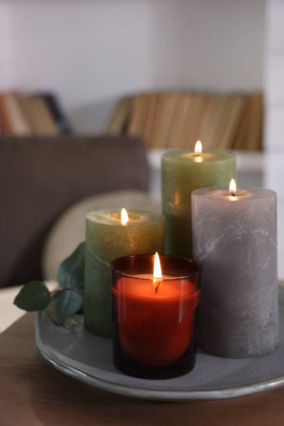 istock Beautiful burning candles on wooden table indoors, space for text 1426547816