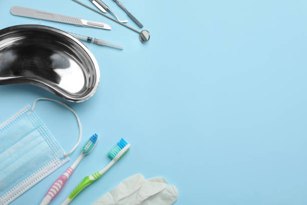 istock Set of different dentist's tools, face mask, toothbrushes and glove on light blue background, flat lay. Space for text 1426547830
