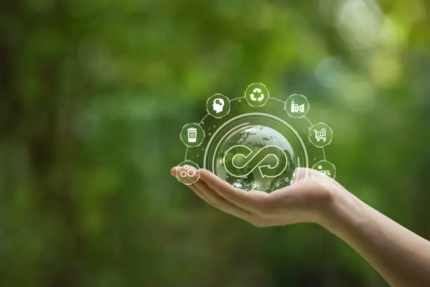 Circular economy concept. Hand-holding crystal globe with a circular economy icon around it. Ideas for future growth of business and design to reuse and renewable material resources.reuse .renewable