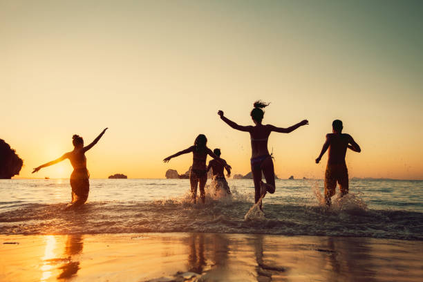 istock Happy friends runs to sunset sea beach 1426548787
