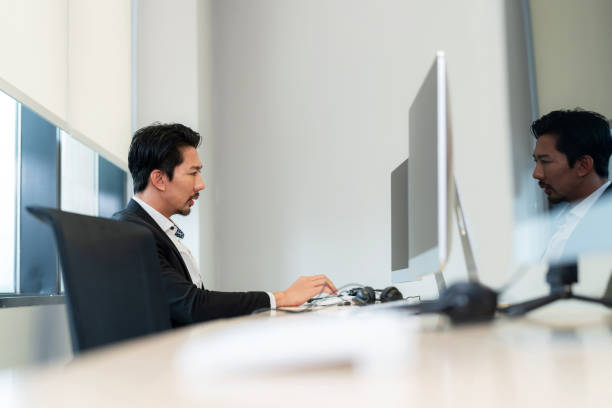istock Asia confident friendly operator man agent with headsets and computer working in a call centermodern office. Senior male conference with customer and smile. Customer support and happy work 1426548905