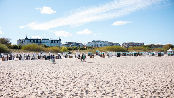 Ahlbeck, Mecklenburg-West Pomerania, Germany - September 21, 2022: View of the promenade on the Baltic Sea beach in Ahlbeck with people in beach chairs on a sunny day
