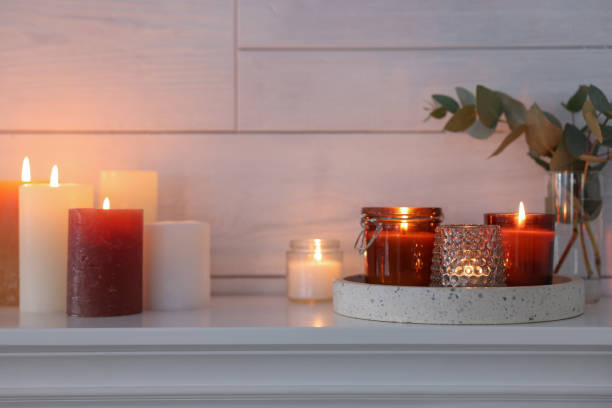 istock Burning candles on mantel near white wall indoors 1426549530