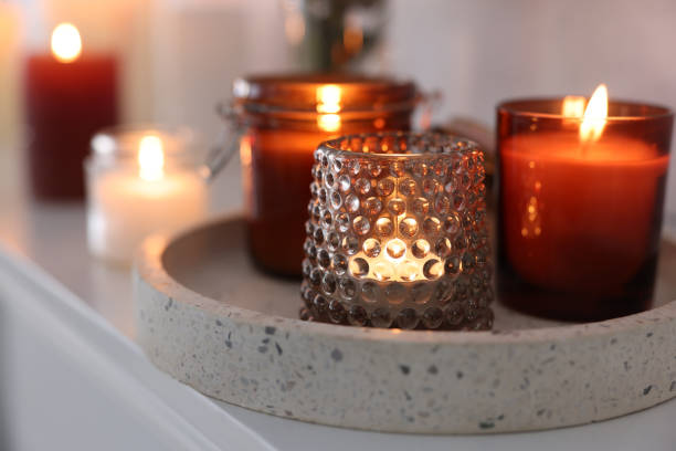 istock Burning candles on mantel near white wall indoors 1426550023