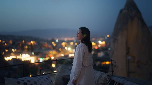 turista femminile che si diverte a guardare la città dal tetto dell'hotel - walking at night foto e immagini stock