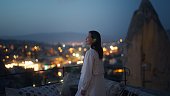 Female tourist enjoying looking over city from rooftop of hotel