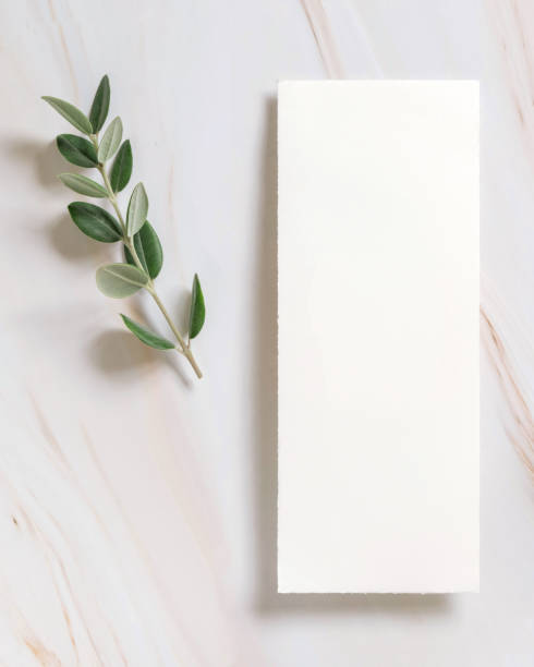 istock Vertical card on a marble table decorated with eucalyptus branches top view, Wedding mockup 1426555028