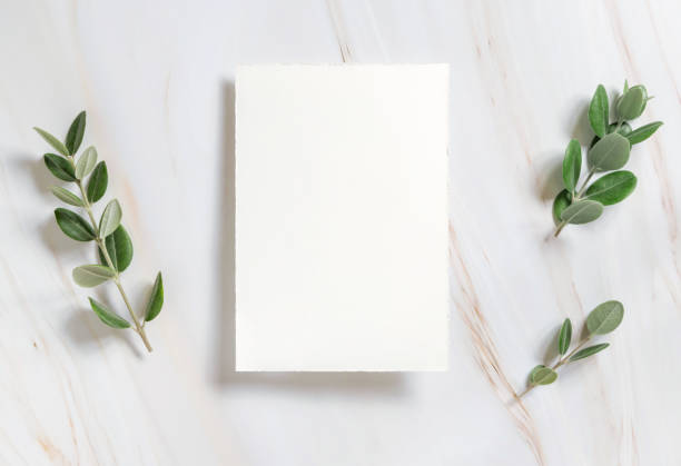istock Vertical card on a marble table decorated with eucalyptus branches top view, Wedding mockup 1426555038