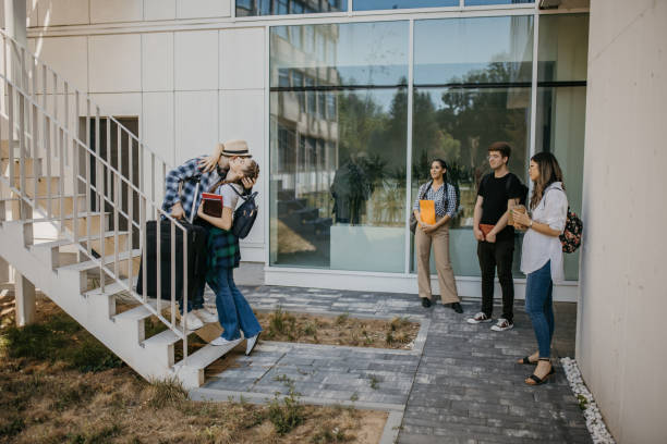istock Student friends hugging in front of college building 1426557378