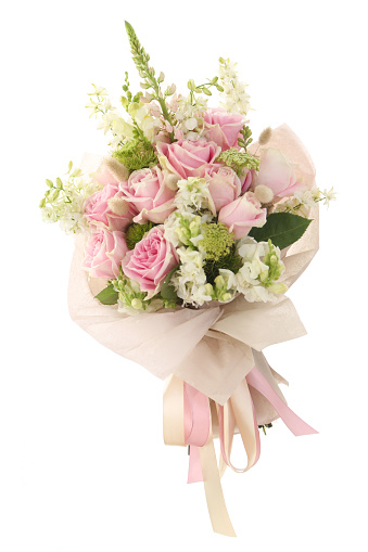 Beautiful bouquet of fresh roses, carnation, freesias, hydrangea, eucalyptus in tender pink and white colors, bouquet of flowers close up.