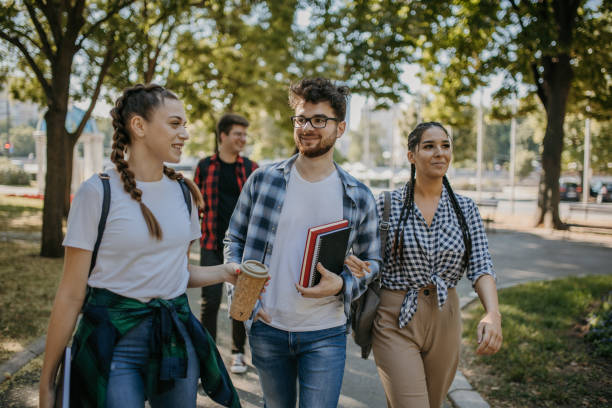 Cheerful students walking in campus stock photo