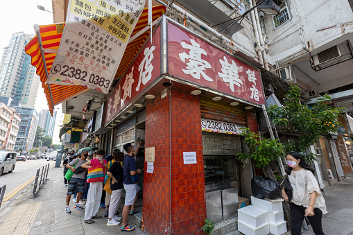 Hong Kong - September 23, 2022 : People queue up outside the Hoover Cake Shop in Ngan Tsin Wai Road, Kowloon City, Hong Kong. The 48-year-old bakery will be officially closing its door on October 1.