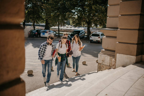 Group of friends chatting while arriving on campus stock photo