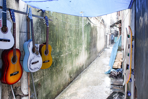 guitar hanging for sale by the roadside in the rain