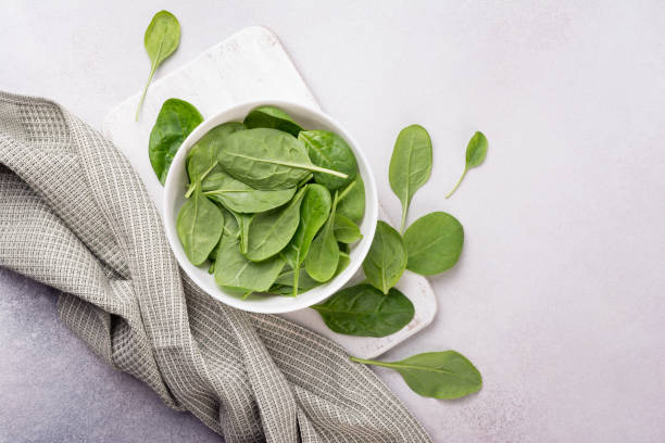 istock Green fresh baby spinach on wooden board 1426564238