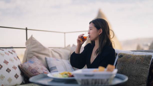 weibliche touristin, die gerne auf dem dach des hotels frühstückt - restaurant sitting adult beauty stock-fotos und bilder