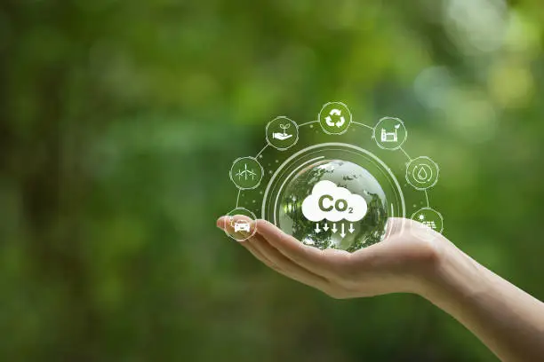 Reduce CO2 emission concept. Hand-holding crystal globe with a CO2 icon. Ideas for Sustainable development and green business based on renewable energy. Energy saving, Sustainable development.