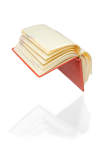 Levitation of an open book on a white background.