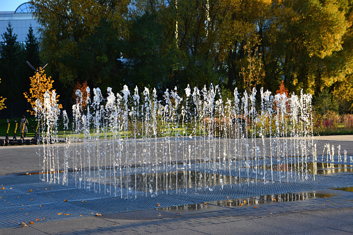 fountain on the street on sunset isolated with trees on background