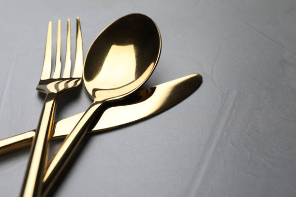 istock Golden cutlery on grey table, closeup. Space for text 1426574085