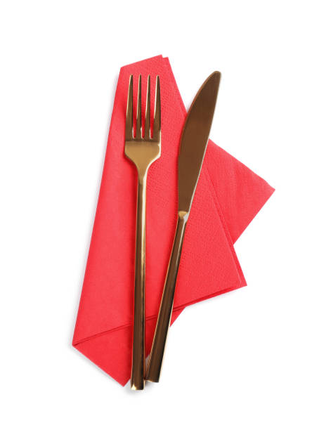istock Red napkin with golden fork and knife on white background, top view 1426574280