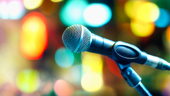 Side view of Microphone on stage with colorful blurred background