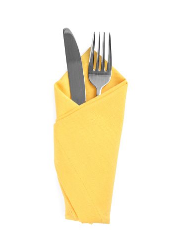 Fork and knife wrapped in yellow napkin on white background, top view