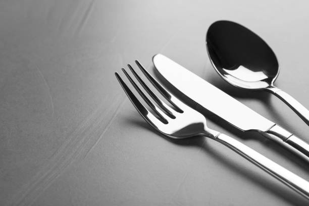 istock Shiny cutlery on grey table, closeup. Space for text 1426576073