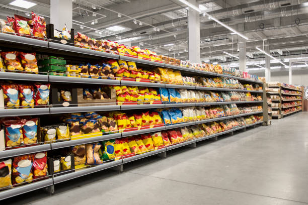 papas fritas y bocadillos en los estantes del supermercado - supermercado fotografías e imágenes de stock